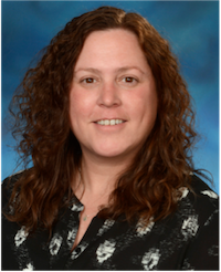 A woman with brown hair wears a black blouse.