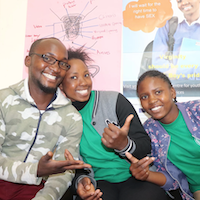 Three people smile for the camera