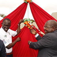 Men cutting ribbon on tent