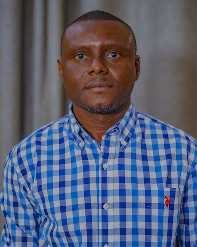 A man wears a blue checkered button down shirt. 