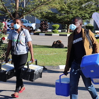 Two people carrying coolers